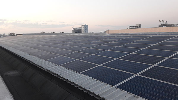 tetto di un'industria ricoperto di pannelli fotovoltaici per impianto industriale