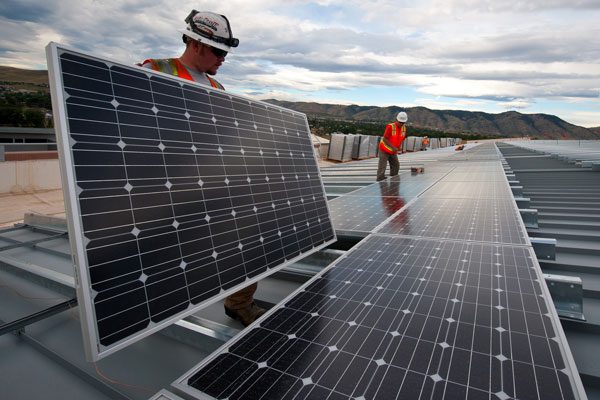 operai che installano dei pannelli fotovoltaici per impianto industriale